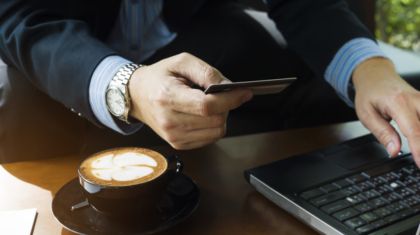 Business man using credit card to buy online items in coffee shop